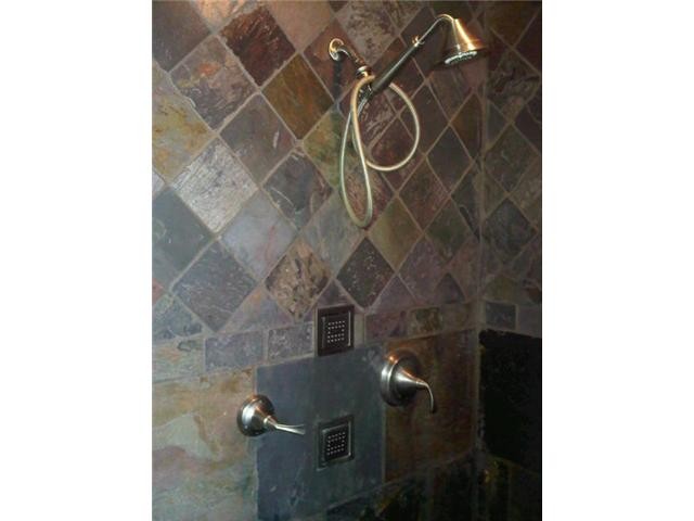 walk in shower complete with kohler body jets. entire master bath is slate, heated floor, duel sinks with a honed quartz countertop, 3 large windows with lake views as you relax in the jetted corner tub.